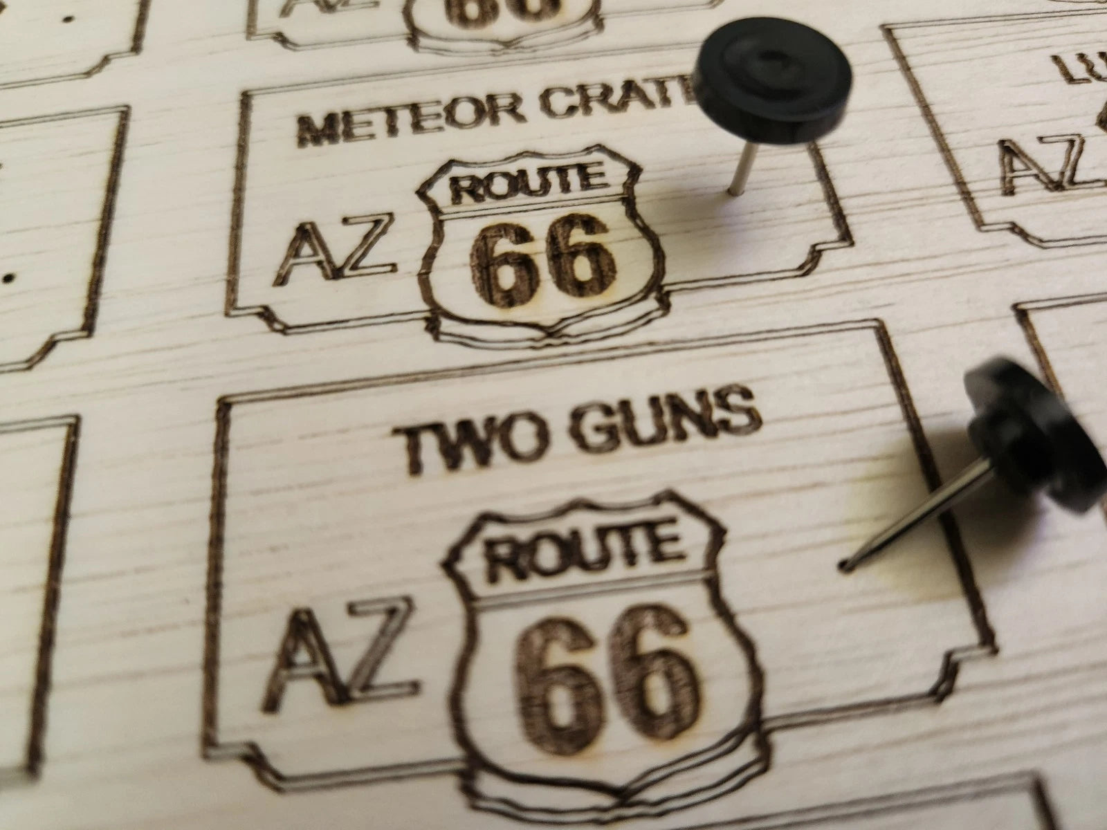Wooden cutouts of Route 66 signs text with push pins